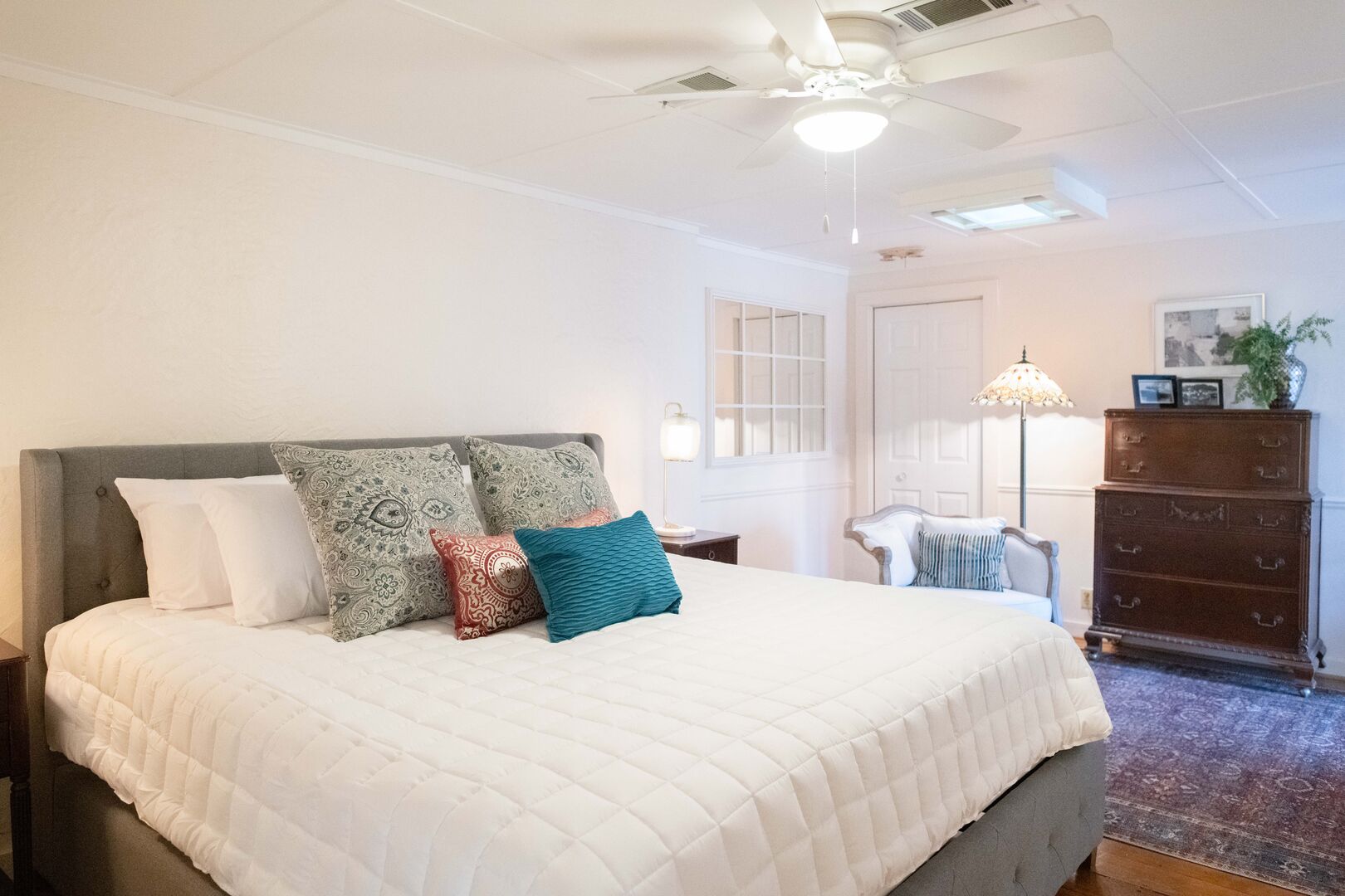 Oversized bedroom with king bed, flat screen TV, sitting area, twin daybed and full bath.