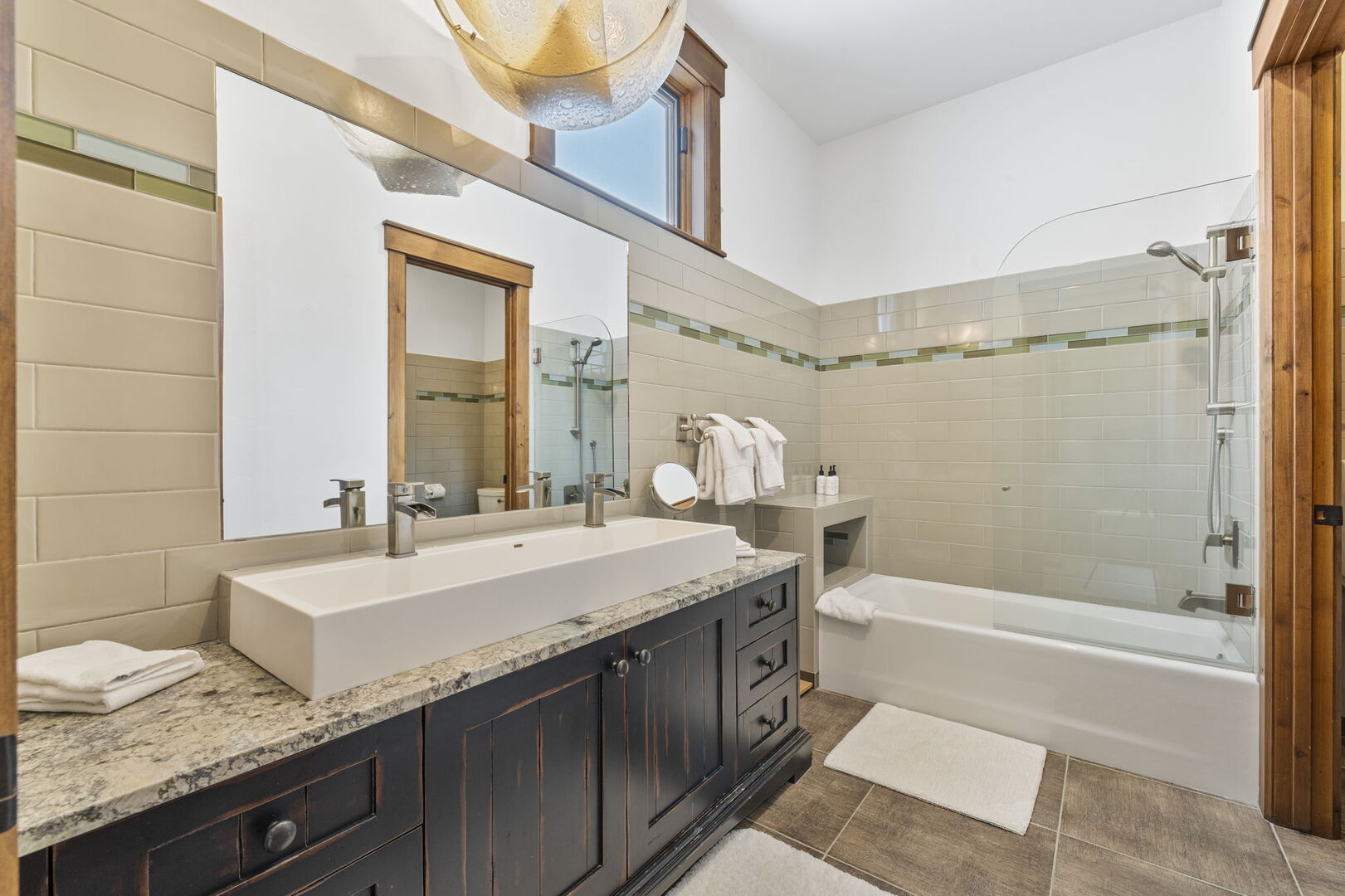 guest en suite bathroom with large sink and double faucets and a tub and shower