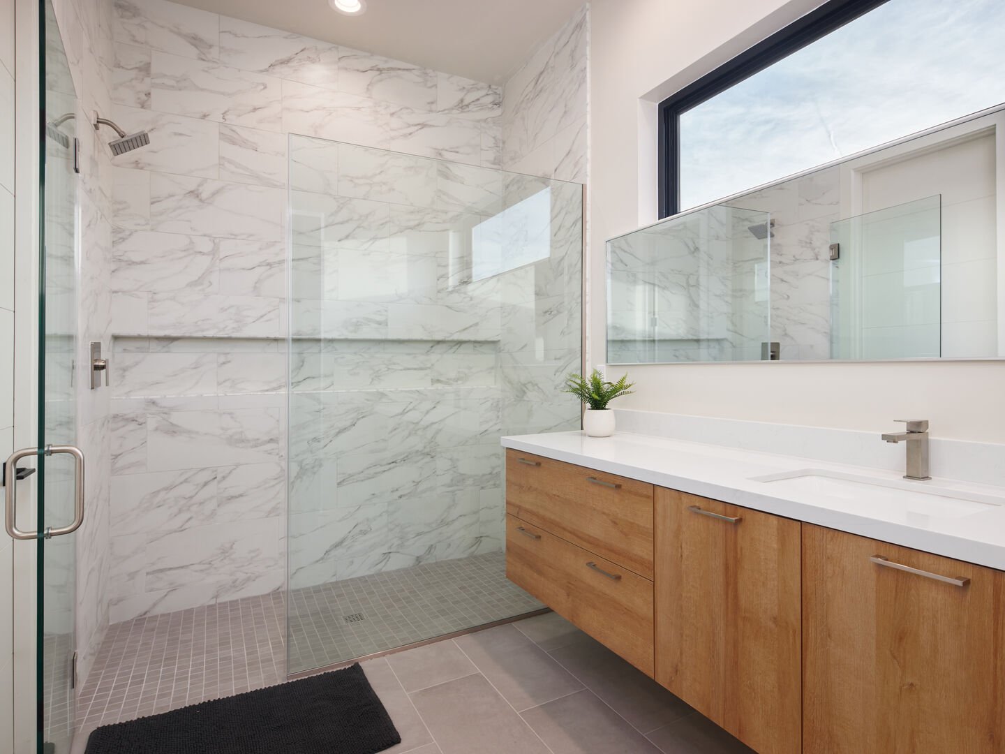 Unit 1: 2nd Bathroom - 2nd Bedroom ensuite featuring a large oversized vanity and a spacious stand-in shower.