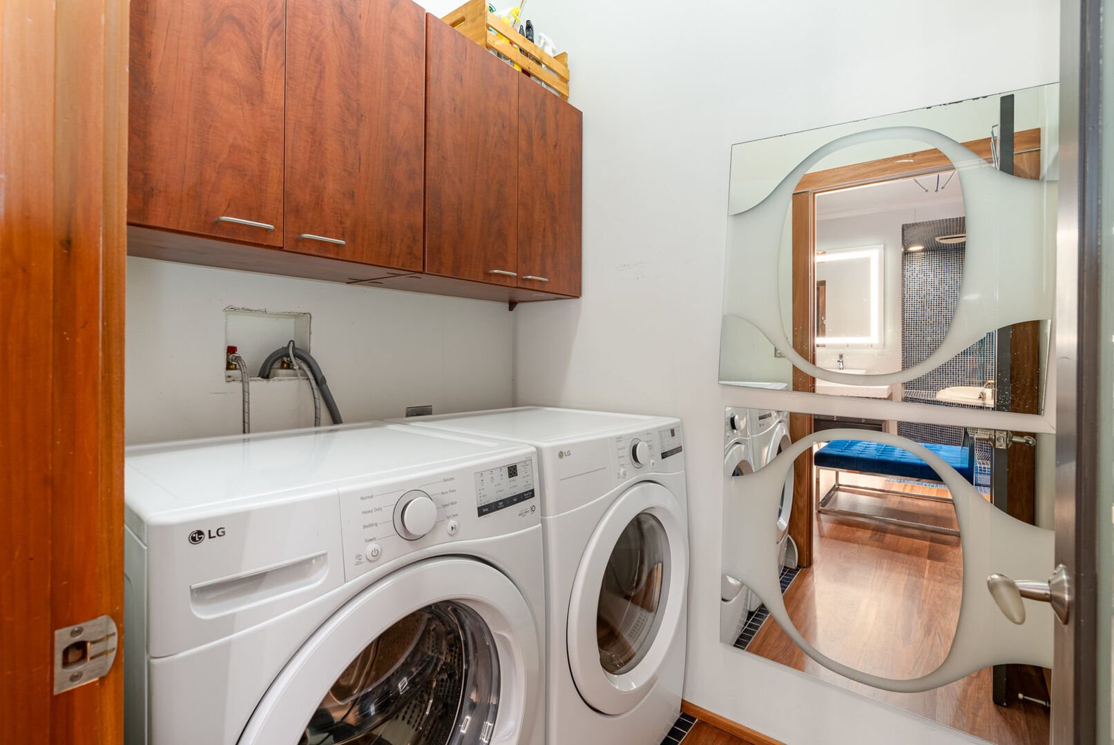 Primary Bathroom featuring a Double Vanity, Bathtub with Jets, Stand-In Shower, and a Laundry Area.