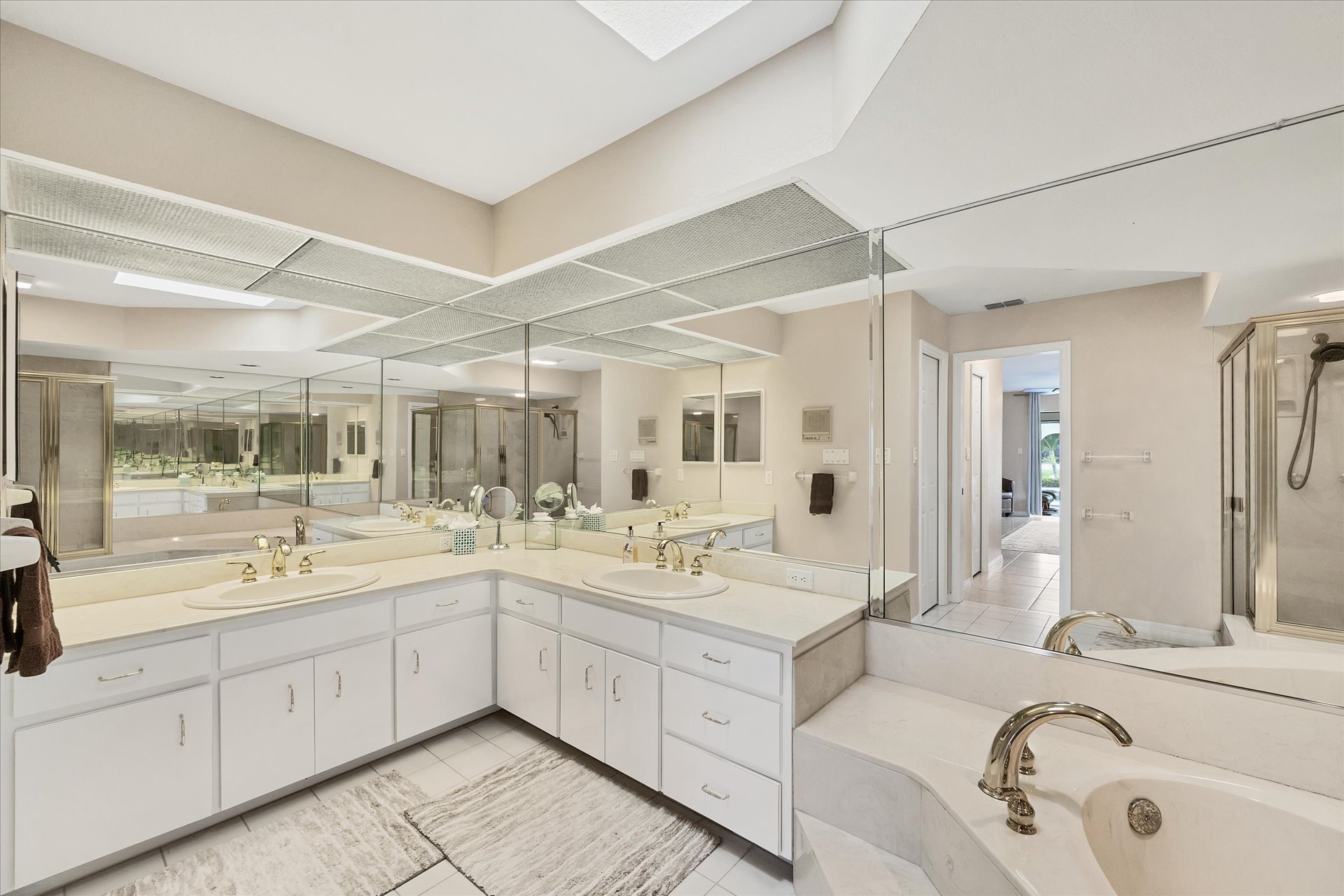 Primary Bathroom with large walk-in shower, double vanities, and bath tub